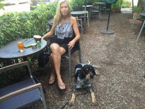 Roscoe lying calmly beside his owner at an outdoor café table